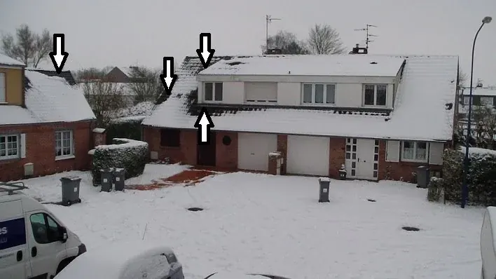 Maison avec d&eacute;perditions visibles (givre, neige fondue sur toit)