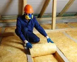 Artisans posant de la laine de verre en comble